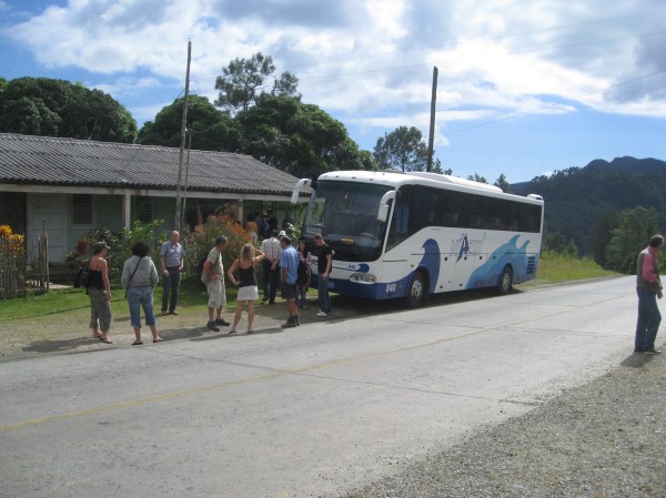 bus stopped by roadway stand.